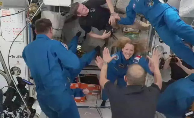 In this image from video provided by NASA, France’s Sophie Adenot, Russia’s Andrei Fedyaev and Americans Jessica Meir and Jack Hathaway greet colleagues as they enter the International Space Station after arriving on a SpaceX Dragon capsule on Saturday, Feb. 14, 2026. (NASA via AP)