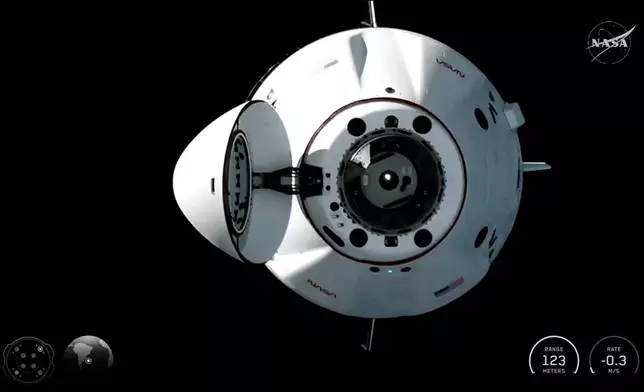 In this image from video provided by NASA, a SpaceX Dragon capsule carrying Americans Meir and Jack Hathaway, France’s Sophie Adenot and Russia’s Andrei Fedyaev, approaches the International Space Station for docking on Saturday, Feb. 14, 2026. (NASA via AP)