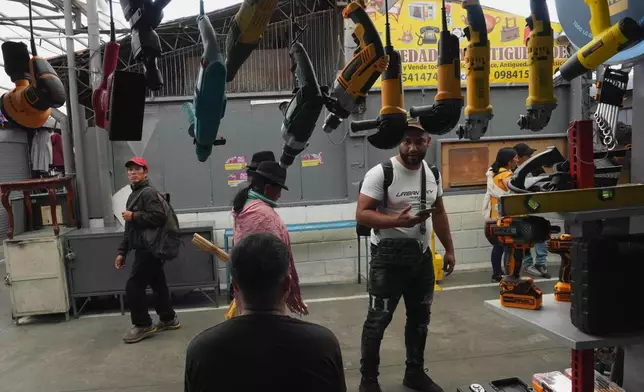 A man stops in front of a store that mostly sells tools imported from China at the Arenas Market in Quito, Ecuador, Saturday, Jan. 31, 2026. (AP Photo/Dolores Ochoa).