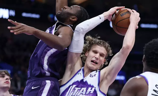 Sacramento Kings forward Precious Achiuwa, left, and Utah Jazz forward Lauri Markkanen battle for a rebound during the first half of an NBA basketball game, Wednesday, Feb. 11, 2026, in Salt Lake City. (AP Photo/Rob Gray)