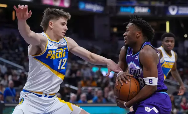 Indiana Pacers guard Johnny Furphy (12) defends Utah Jazz guard Isaiah Collier (8) during the second half of an NBA basketball game in Indianapolis, Tuesday, Feb. 3, 2026. (AP Photo/Michael Conroy)