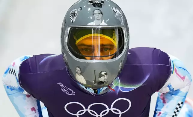 Ukraine's Vladyslav Heraskevych arrives at the finish during a men's skeleton training session at the 2026 Winter Olympics, in Cortina d'Ampezzo, Italy, Wednesday, Feb. 11, 2026. (AP Photo/Alessandra Tarantino)