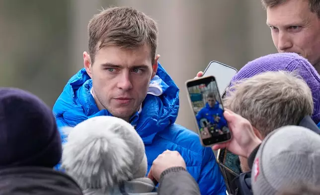 Ukraine's Vladyslav Heraskevych, left, talks to the media during a men's skeleton training session at the 2026 Winter Olympics, in Cortina d'Ampezzo, Italy, Wednesday, Feb. 11, 2026. (AP Photo/Alessandra Tarantino)