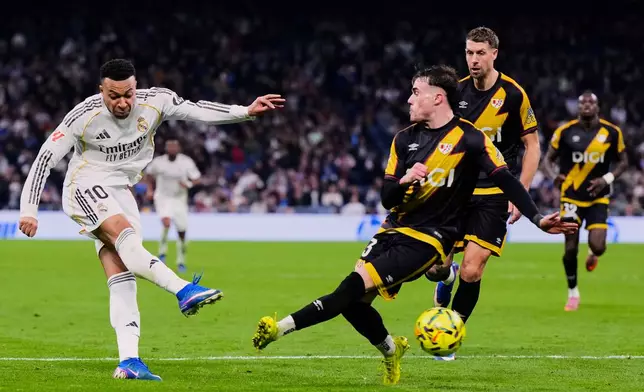 Real Madrid's Kylian Mbappe, left, tries a shot during the Spanish La Liga soccer match between Real Madrid and Rayo Vallecano in Madrid, Spain, Sunday, Feb. 1, 2026. (AP Photo/Manu Fernandez)