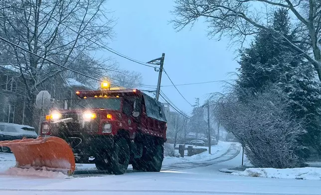 A plow starts removing snow from a residential street during the beginning of an intense winter storm, Sunday, Feb. 22, 2026, in Fort Lee, N.J. (AP Photo/Pablo Salinas)