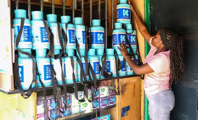 Laurine Akhutu, a KOKO Cooker bioethanol fuel vendor, arranges fuel bottles at her shop in the Kibera informal settlement on the outskirts of Nairobi, Kenya, Wednesday, Feb. 4, 2026. (AP Photo/Atieno Muyuyi)