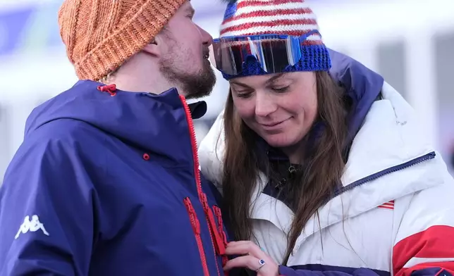 United States' Breezy Johnson, right, and fiancee Connor Watkins are interviewed after he proposed to her at the end of an alpine ski, women's super-G race, at the 2026 Winter Olympics, in Cortina d'Ampezzo, Italy, Thursday, Feb. 12, 2026. (AP Photo/Jacquelyn Martin)