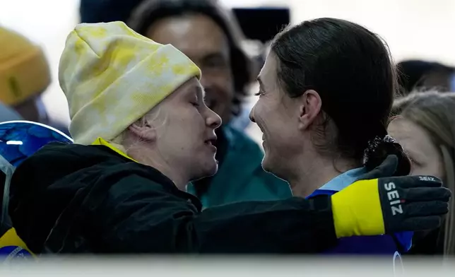 Belgium's Kim Meylemans, left, and Brazil's Nicole Rocha Silveira react, at the finish during a women's skeleton run at the 2026 Winter Olympics, in Cortina d'Ampezzo, Italy, Friday, Feb. 13, 2026. (AP Photo/Alessandra Tarantino)