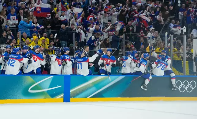 Slovakia players celebrate after their teammate Slovakia's Dalibor Dvorsky scores his side's third goal during a preliminary round match of men's ice hockey between Sweden and Slovakia at the 2026 Winter Olympics, in Milan, Italy, Saturday, Feb. 14, 2026. (AP Photo/Petr David Josek)