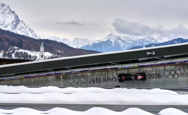 Canada's Taylor Austin, front, and Shaquille Murray-Lawrence slide down the track during a two man bobsled run at the 2026 Winter Olympics, in Cortina d'Ampezzo, Italy, Monday, Feb. 16, 2026. (AP Photo/Aijaz Rahi)