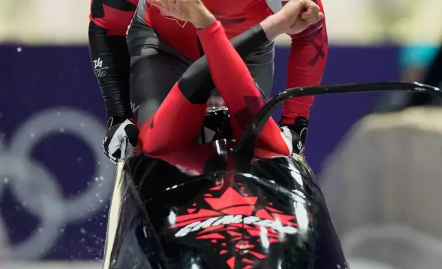 Canada's Taylor Austin, front, and Shaquille Murray-Lawrence start for a two man bobsled run at the 2026 Winter Olympics, in Cortina d'Ampezzo, Italy, Monday, Feb. 16, 2026. (AP Photo/Alessandra Tarantino)