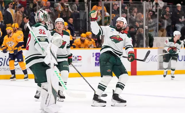 Minnesota Wild defenseman Zach Bogosian, right, and defenseman Brock Faber, center, celebrate the teams overtime win with goaltender Filip Gustavsson (32) after an NHL hockey game against the Nashville Predators, Wednesday, Feb. 4, 2026, in Nashville, Tenn. (AP Photo/George Walker IV)