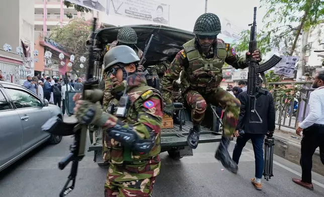 Army personnel jump from a vehicle outside a polling station during national parliamentary election in Dhaka, Bangladesh, Thursday, Feb. 12, 2026. (AP Photo/Anupam Nath)