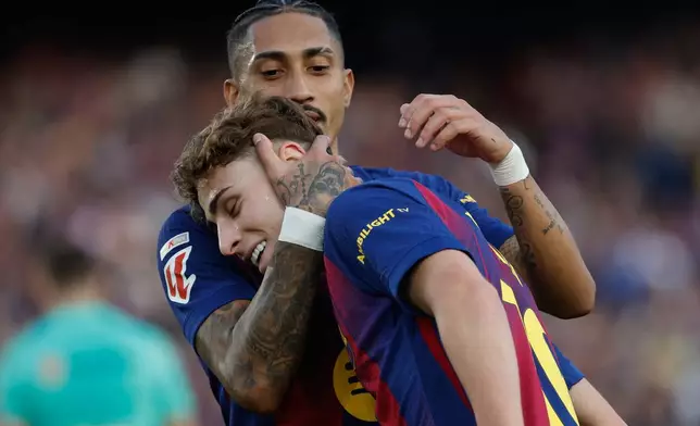 Barcelona's Raphinha hugs Fermin Lopez after a goal during a La Liga soccer match between Barcelona and Levante in Barcelona, Spain, Sunday, Feb. 22, 2026. (AP Photo/Joan Monfort)