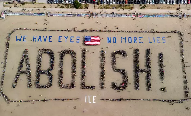 In an aerial view, protesters form a human banner on Ocean Beach during a protest amidst the ongoing nationwide federal immigration raids and unrest in Minneapolis, in San Francisco, Saturday, Jan. 31, 2026. (Stephen Lam/San Francisco Chronicle via AP)