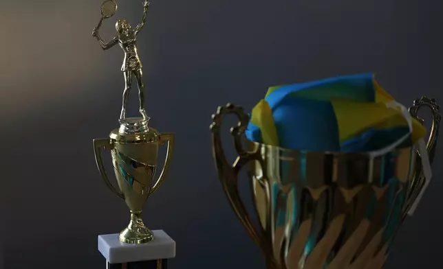A trophy and the flag of Ukraine belonging to Mariia Vainshtein sits on a table at the Cary Leeds Center for Tennis and Learning in the Bronx borough of New York, Saturday, Jan. 31, 2026. (AP Photo/Heather Khalifa)