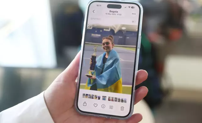 Anzhelika Kotlyantseva shows an old photo of her daughter, Mariia Vainshtein, wearing the flag of Ukraine after she won a tennis tournament at the Cary Leeds Center for Tennis and Learning in the Bronx borough of New York, Saturday, Jan. 31, 2026. (AP Photo/Heather Khalifa)