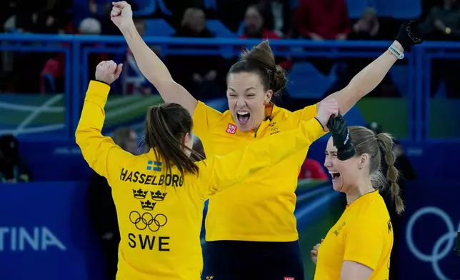 Sweden's Anna Hasselborg, left, celebrates with teammates after winning a women's curling semifinal match against Canada, at the 2026 Winter Olympics, in Cortina d'Ampezzo, Italy, Friday, Feb. 20, 2026. (AP Photo/Misper Apawu)