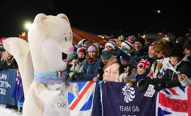 Olympic mascot Tina interacts with fans before the women's snowboarding big air finals at the 2026 Winter Olympics, in Livigno, Italy, Monday, Feb. 9, 2026. (AP Photo/Lindsey Wasson)