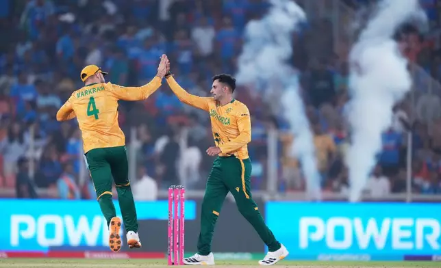 South Africa's Keshav Maharaj, right, celebrates with captain Aiden Markram the wicket of India's Arshdeep Singh during the T20 World Cup cricket match between India and South Africa in Ahmedabad, India, Sunday, Feb. 22, 2026. (AP Photo/Ajit Solanki)