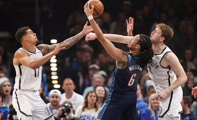 Brooklyn Nets forward Michael Porter Jr., left, Nets forward Danny Wolf, right, and Oklahoma City Thunder forward Jaylin Williams (6) try to grab a rebound during the first half of an NBA basketball game Friday, Feb. 20, 2026, in Oklahoma City. (AP Photo/Nate Billings)