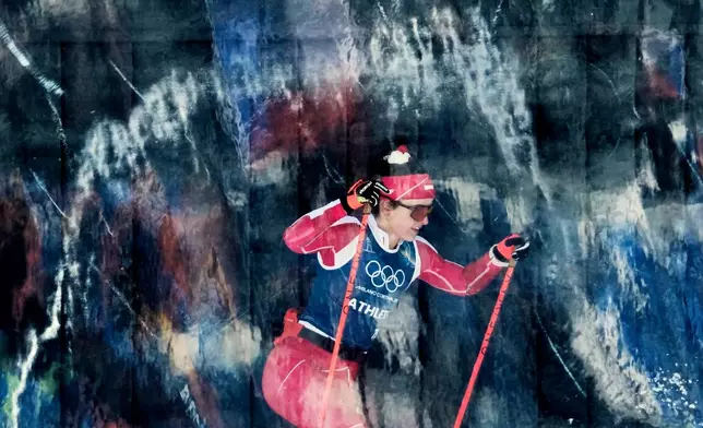 Poland's Anna Maka passes behind a glass wall while training on the biathlon course at the 2026 Winter Olympics, in Anterselva, Italy, Friday, Feb. 20, 2026. (AP Photo/David J. Phillip)