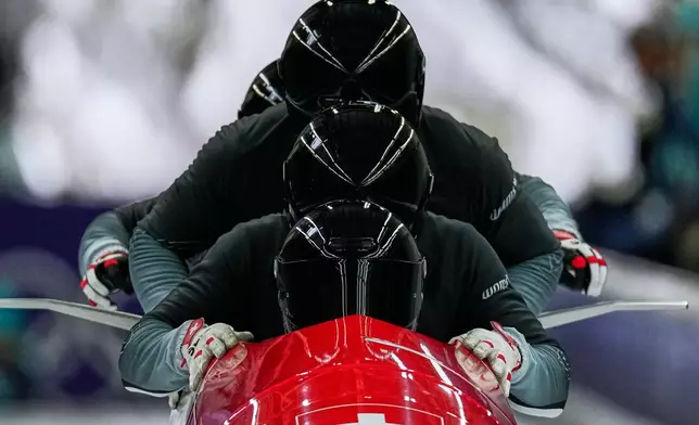 Switzerland's Michael Vogt, front, starts for a four man bobsled training session at the 2026 Winter Olympics, in Cortina d'Ampezzo, Italy, Friday, Feb. 20, 2026. (AP Photo/Alessandra Tarantino)