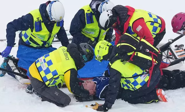 Medics respond after New Zealand's Finley Melville Ives crashed during the men's freestyle skiing halfpipe qualifications at the 2026 Winter Olympics, in Livigno, Italy, Friday, Feb. 20, 2026. (AP Photo/Gregory Bull)