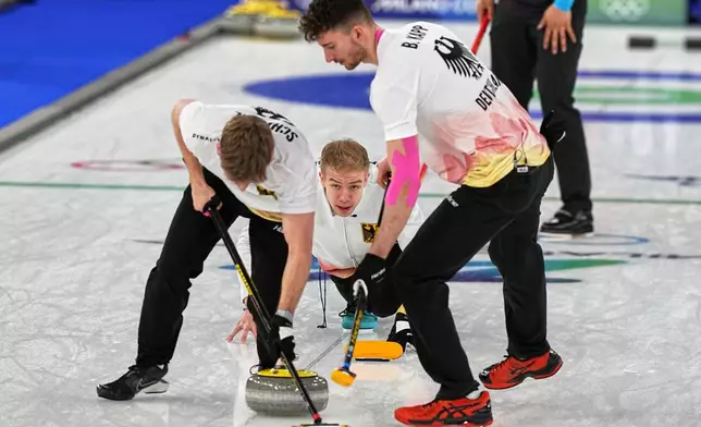 Germany's Benjamin Kapp, Felix Messenzehl and Johannes Scheuerl in action during the men's curling round robin session against China at the 2026 Winter Olympics, in Cortina d'Ampezzo, Italy, Thursday, Feb. 19, 2026. (AP Photo/Fatima Shbair)
