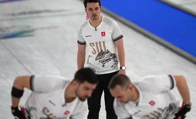Switzerland's Schwarz-van Berkel Benoit, Sven Michel and Pablo Lachat-Couchepinin action during the men's curling round robin session against Italy at the 2026 Winter Olympics, in Cortina d'Ampezzo, Italy, Thursday, Feb. 19, 2026. (AP Photo/Fatima Shbair)