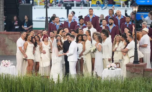 A couple dressed as a bride and groom participate in the Bad Bunny performance during halftime of the NFL Super Bowl 60 football game between the Seattle Seahawks and the New England Patriots, Sunday, Feb. 8, 2026, in Santa Clara, Calif. (AP Photo/Frank Franklin II)