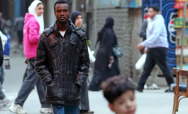Mustafa Khater, a 28-year-old charity kitchen worker who fled with his pregnant wife a few days before el-Fasher fell to the RSF, walks at his neighborhood in Cairo, Egypt, Wednesday, Jan. 14, 2026. (AP Photo/Khaled el Fiqi)