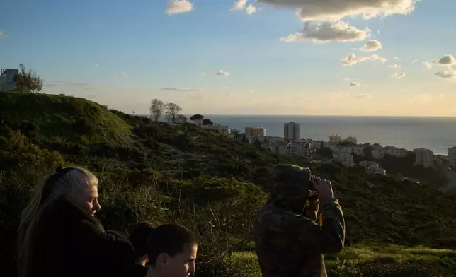 From a lookout, a man uses a binocular looking for the possible arrival of the US Navy's aircraft carrier USS Gerald R. Ford in the Mediterranean Sea near the coast of Haifa, northern Israel, Friday, Feb. 27, 2026. (AP Photo/Leo Correa)