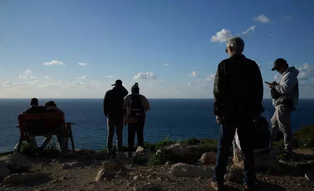 People gather at a lookout to look for the possible arrival of the US Navy's aircraft carrier USS Gerald R. Ford in the Mediterranean Sea near the coast of Haifa, northern Israel, Friday, Feb. 27, 2026. (AP Photo/Leo Correa)