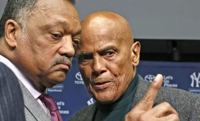 FILE - Rev. Jesse Jackson, left, talks with singer and civil right rights activist Harry Belafonte after a news conference announcing the installation of a Nelson Mandela plaque in Yankee Stadium's Monument Park in New York, April 16, 2014. (AP Photo/Kathy Willens, File)