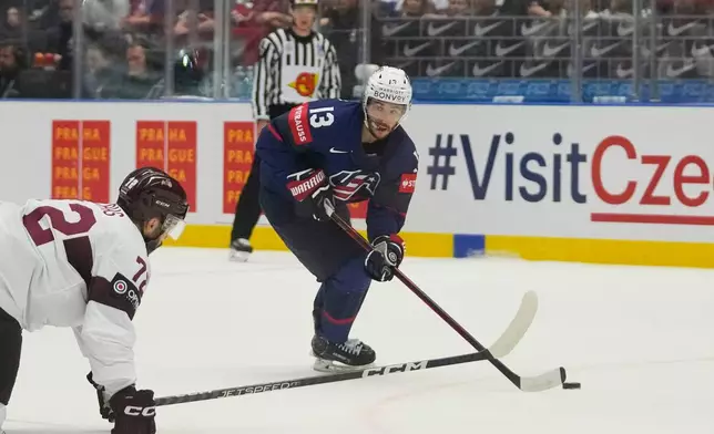 FILE - United States' Johnny Gaudreau, right, challenges for a puck with Latvia's Janis Jaks during the preliminary round match between Latvia and United States at the Ice Hockey World Championships in Ostrava, Czech Republic, Tuesday, May 21, 2024. (AP Photo/Darko Vojinovic, File)