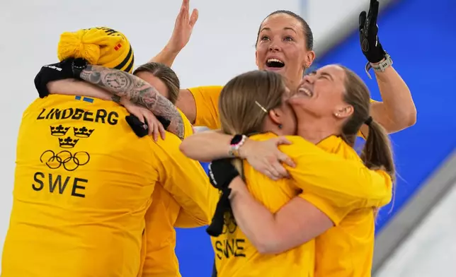 Team Sweden celebrates defeating Switzerland to win a women's curling gold medal match, at the 2026 Winter Olympics, in Cortina d'Ampezzo, Italy, Sunday, Feb. 22, 2026.(AP Photo/Fatima Shbair)