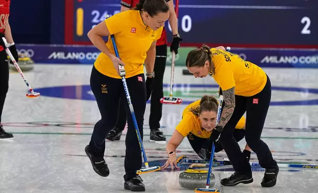Sweden's Sara McManus, centre, Agnes Knochenhauer, left, and Sofia Scharback compete during a women's curling gold medal match between Switzerland and Sweden, at the 2026 Winter Olympics, in Cortina d'Ampezzo, Italy, Sunday, Feb. 22, 2026. (AP Photo/Fatima Shbair)