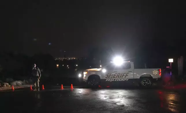 Pima County Sheriff block a road near Nancy Guthrie's home in Tucson, Ariz. on Friday, Feb. 13, 2026. (AP Photo/Ty ONeil)