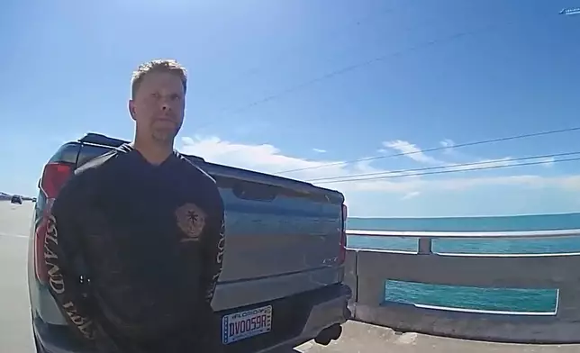 In this screengrab made from body camera footage provided by the Monroe County, Fla., Sheriff's Office, off-duty U.S. Immigration and Customs Enforcement agent Scott Deiseroth takes a field sobriety test after he was pulled over for drunk driving with his children in the car in August 2025. (Monroe County Sheriff's Office via AP)