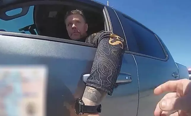 In this screengrab made from body camera footage provided by the Monroe County, Fla., Sheriff's Office, off-duty U.S. Immigration and Customs Enforcement agent Scott Deiseroth argues with a deputy who pulled him over for drunk driving with his children in the car in August 2025. (Monroe County Sheriff's Office via AP)