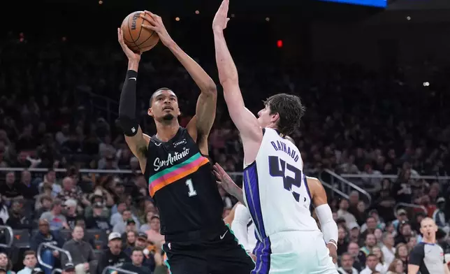 San Antonio Spurs forward Victor Wembanyama (1) shoots past Sacramento Kings center Maxime Raynaud (42) during the second half of an NBA basketball game in Austin, Texas, Saturday, Feb. 21, 2026. (AP Photo/Eric Gay)