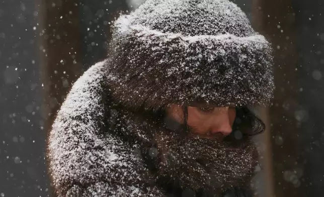 FILE - Pedestrians walk down Fifth Avenue during a winter storm Jan. 25, 2026, in New York. (AP Photo/Heather Khalifa, File)