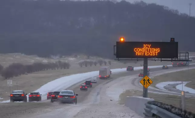 FILE - Vehicles travel eastbound on Interstate 20 near a sign advising motorists of icy conditions during a winter storm Jan. 24, 2026, in Dallas. (AP Photo/Julio Cortez, File)