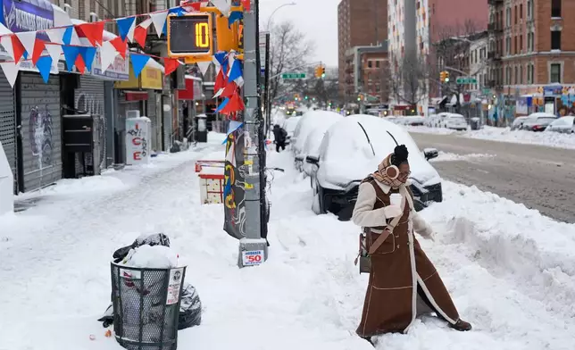 FILE - Carrie Hampton tries to navigate a snowy intersection without spilling her coffee in New York, Jan. 26, 2026. (AP Photo/Seth Wenig, File)