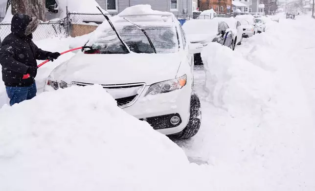 FILE - Rafael Tavares digs his car, which was encased about 20 inches of snow, during a winter storm Jan. 26, 2026, in Lawrence, Mass. (AP Photo/Charles Krupa, File)