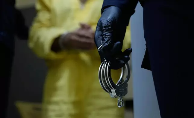 Iraqi security forces lead suspected Islamic State militants for questioning, after they were transferred from Syria to Iraq, at Al-Karkh Central Prison in Baghdad, Iraq, Thursday, Feb. 12, 2026. (AP Photo/Hadi Mizban)