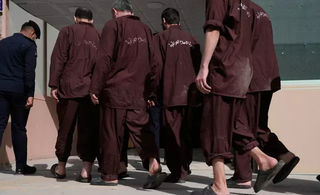 Iraqi security forces lead suspected Islamic State militants for questioning, after they were transferred from Syria to Iraq, at Al-Karkh Central Prison in Baghdad, Iraq, Thursday, Feb. 12, 2026. (AP Photo/Hadi Mizban)