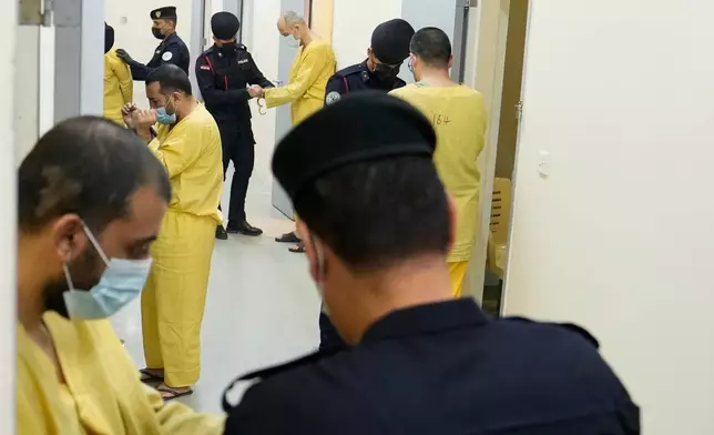 Iraqi security forces lead suspected Islamic State militants for questioning, after they were transferred from Syria to Iraq, at Al-Karkh Central Prison in Baghdad, Iraq, Thursday, Feb. 12, 2026. (AP Photo/Hadi Mizban)