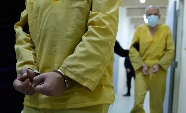 Iraqi security forces lead suspected Islamic State militants for questioning, after they were transferred from Syria to Iraq, at Al-Karkh Central Prison in Baghdad, Iraq, Thursday, Feb. 12, 2026. (AP Photo/Hadi Mizban)